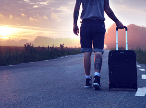 Tattooed man travelling with suitcase